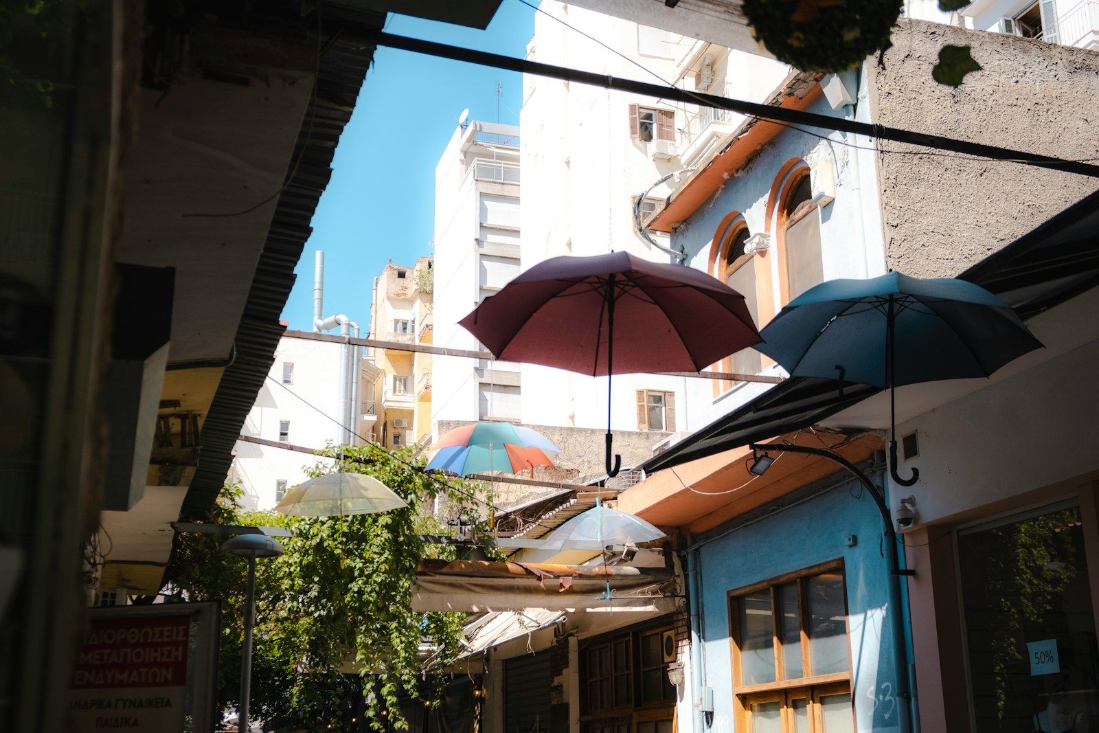 an alleyway with umbrellas and buildings in the background
